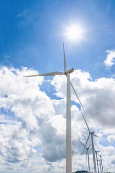 Beautiful windmill under the sun on blue sky and white clouds background, Clean energy eco-friendly electric power source help reduce global warming