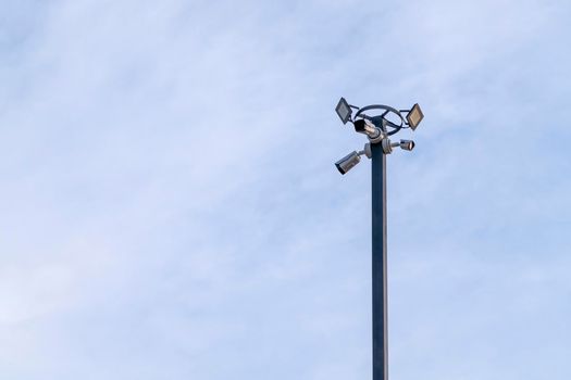 outdoor security camera on a lamppost against a blue sky. High quality photo