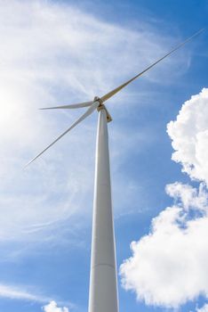 Beautiful wind turbine on blue sky and white clouds background, Eco-friendly electric power source Help reduce global warming