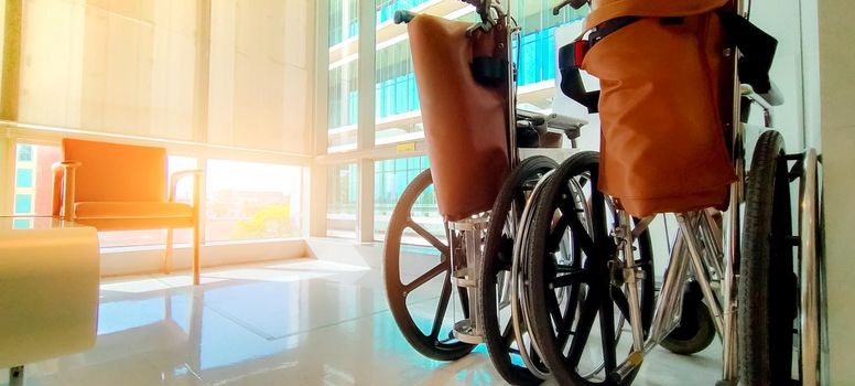 Empty wheelchair in private hospital for service patient and disabled people. Medical equipment in hospital for assistance handicapped old people. Chair with wheels for patient care in nursing home.