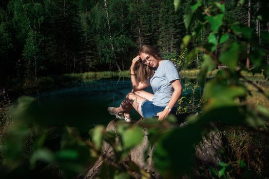 Woman resting at mountain lake in summer, Altai mountains