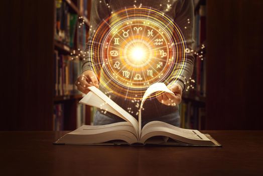 Woman reading a astrology book. Astrological wheel projection, choose a zodiac sign. Trust horoscope future predictions, consulting stars. Power of universe, astrology esoteric concept.