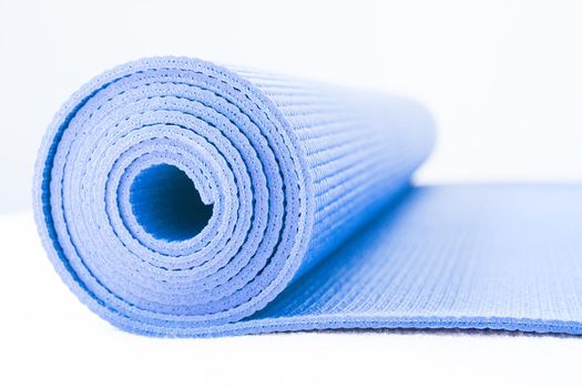 Rolled up yoga or pilates mat. No people