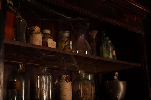 Halloween background Shelves with alchemy tools Skull spiderweb bottle with poison candles Witcher workspace Scarry room