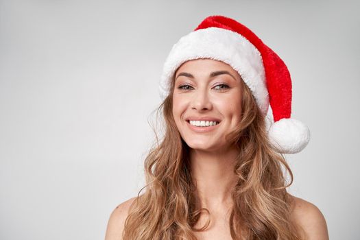 Woman christmas Santa Hat white studio background Beautiful caucasian female curly hair portrait Happy person positive emotion Holiday concept Close up face portrait