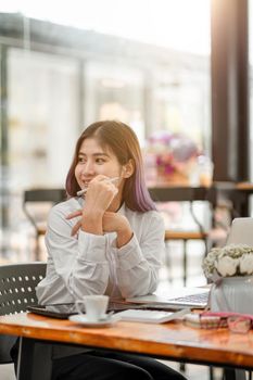 Portrait of smiling pretty young business asian woman working with laptop computer for financial on workplace, Accounting concept