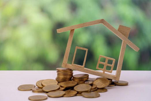 Miniature Wood house model on stack money coin and background eco. Home Eco and Real Estate concept.