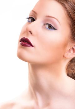 Close-up beauty shot of a young female model with classic eyeliner, black and blue mascara, and glowing clean skin, isolated on white background. Beauty and make up concept. Classic make up with a twist.