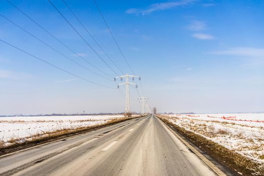 Winter season, view of cars and snowy street through windshield while driving in Bucharest, Romania, 2021.