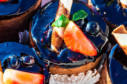 Chocolate mousse cakes decorated with strawberry and chocolate stick.