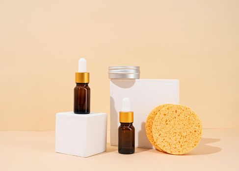 Natural organic selfcare products. Brown bottles mockup for natural skincare essential oils, spa accessories on white podiums, cream background. Spa accessories creative art composition on beige background