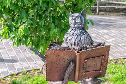 sculpture of an owl with a book in the park. High quality photo