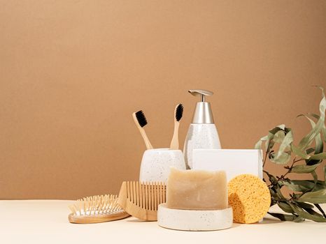 Natural organic selfcare products. Handmade soap, wooden brush and bamboo toothbrushes. Spa accessories creative art composition on beige background