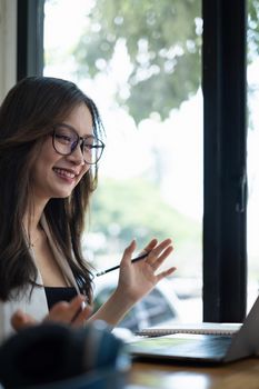 Business woman try to explain about his work to business team by video call at home office