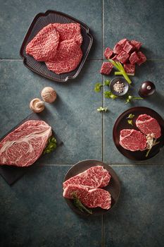 Top view of raw beef steaks on gray background