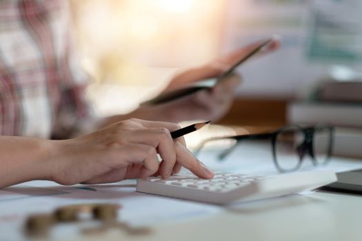 Close up woman calculating monthly home expenses, taxes, bank account balance and credit card bills payment, Income is not enough for expenses.