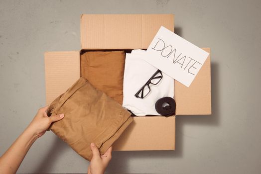 People Putting Clothes Inside Donation Box