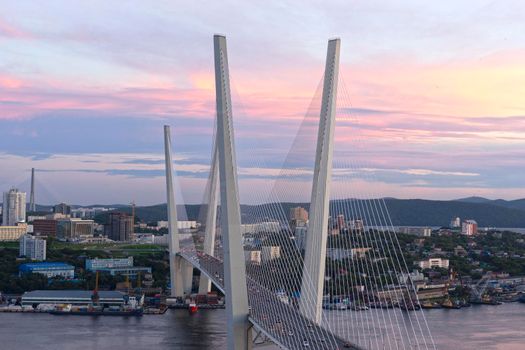 Urban landscape with a view of the Golden Bridge at sunset. Vladivostok, Russia.