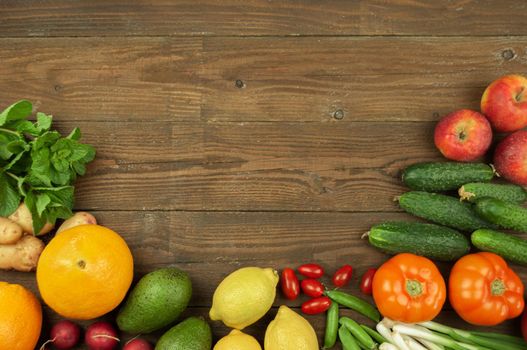 Flexitana diet concept.Composition with assorted fresh organic vegetables and fruits.Place for text.Cucumbers,tomatoes,radish, avocado, peas,potatoes,lemon,onions.Food on dark wooden background.