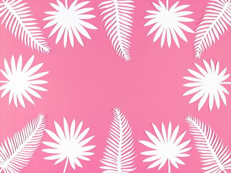 Tropical paper leaves on a pink background, flat lay with copy space.