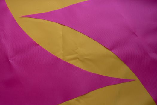 Pink pieces of fabric lie on the yellow fabric.