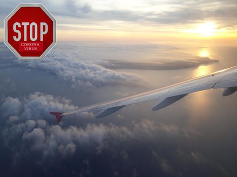Stop sign with text "Corona Virus " view from airplane above Chine country.  Novel coronavirus 2019-nCoV, MERS-Cov. Passengers airplane flying above clouds in sunset light
