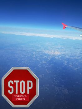 Covid-19 Virus. View from plane window to China country with coronavirus written on stop sign. Landing of passanger airplane.