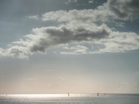Beginning windsurfer riding in calm  sea. Windsurfer in the sea, man on windsurf conquering the waves, enjoying extreme sport, active lifestyle, happy summer vacation.