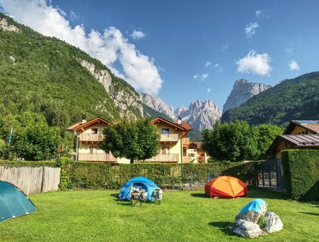 Camping within summer holiday. Trekking tents in touristic camp in Italien Alps.