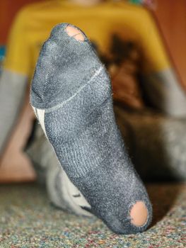 Worn socks with a hole and heel sticking out. Old worn clothes