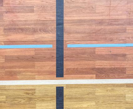 Renewal wooden floor of sports hall with marking lines and new lacquered surface. Background texture of old white painted wooden lining boards wall.