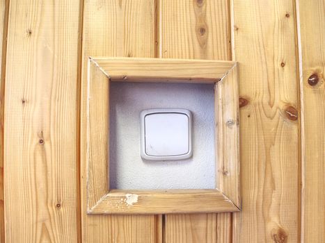 White switcher on wall. Brown wooden wall with white switch, background. Home interior decor.