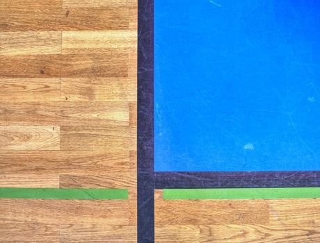 Hall floor in a gymnasium with diverse lines. Worn out wooden floor of sports hall with colorful marking lines. Schooll gym hall