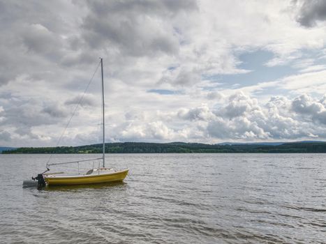 Boat anchored in calm bay. Touristic resort with nobody.  Calm water level, idilic walk at shore.