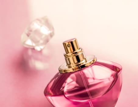 Perfumery, spa and branding concept - Pink perfume bottle on glossy background, sweet floral scent, glamour fragrance and eau de parfum as holiday gift and luxury beauty cosmetics brand design