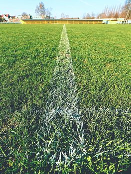 Border of painted white lines on natural dry football grass. Cut green turf texture. 