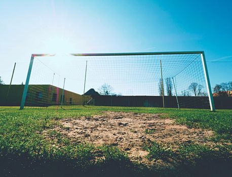 Hang bended blue yellow soccer nets, soccer football net. Grass on football playground in the background 