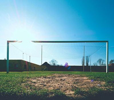 Soccer football net background over green grass and blurry stadium. Football,soccer field. Football,soccer and goal background. Soccer goal