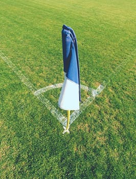 White blue flag in corner of football playground, lazy wind blowing