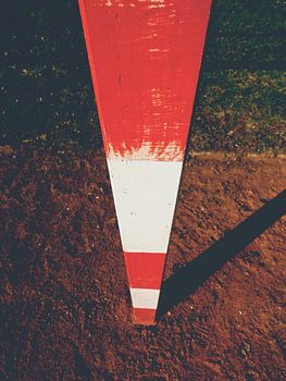 Detail of gate frame . Outdoor football or handball playground, light red crushed bricks surface on ground