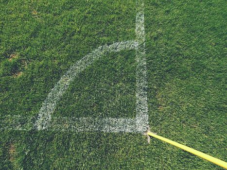 Football field corner detail with white marks and flag stick