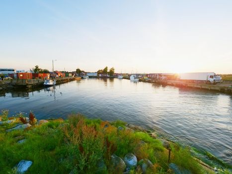 Small port at fishing village  with small fishing boats. Quiet bay at stony dam. Summer traveling in Sweden. Sunny evening.