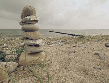 Pyramid of sea stones on pebbles beach. The sea shore. Seascape. 