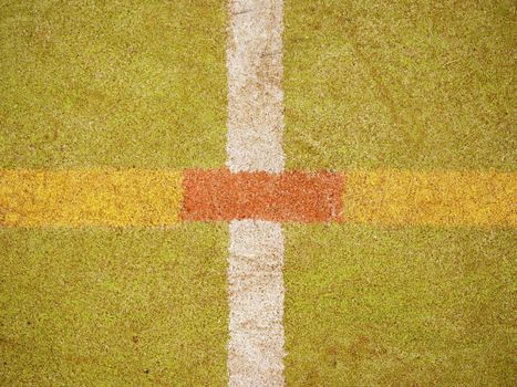 Border lines on court. Worn out green red hairy carpet on outside hanball playground. Floor of sports court with white marking lines.