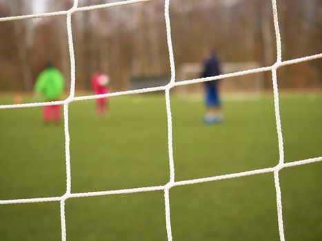 Soccer football net background over green grass and blurry stadium. Close up detail of a soccer net Footballsoccer field.  


