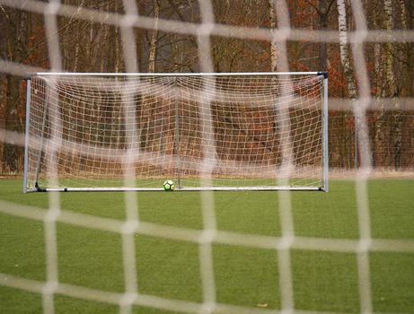 Football gate net. Soccer gate net. In blurry background stand players. Training of junior team. 