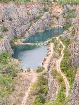 Blue lagoon at the bottom of area Amerika canyon, Czech Republic. Wild nature in a stone canyon background