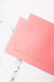 Pink A4 papers on white marble background as office stationery flatlay, luxury branding flat lay and brand identity design for mockups