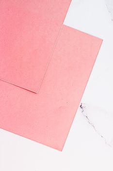 Pink A4 papers on white marble background as office stationery flatlay, luxury branding flat lay and brand identity design for mockups