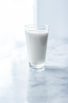 Dairy, healthy nutrition and breakfast concept - World Milk Day, full glass on marble table